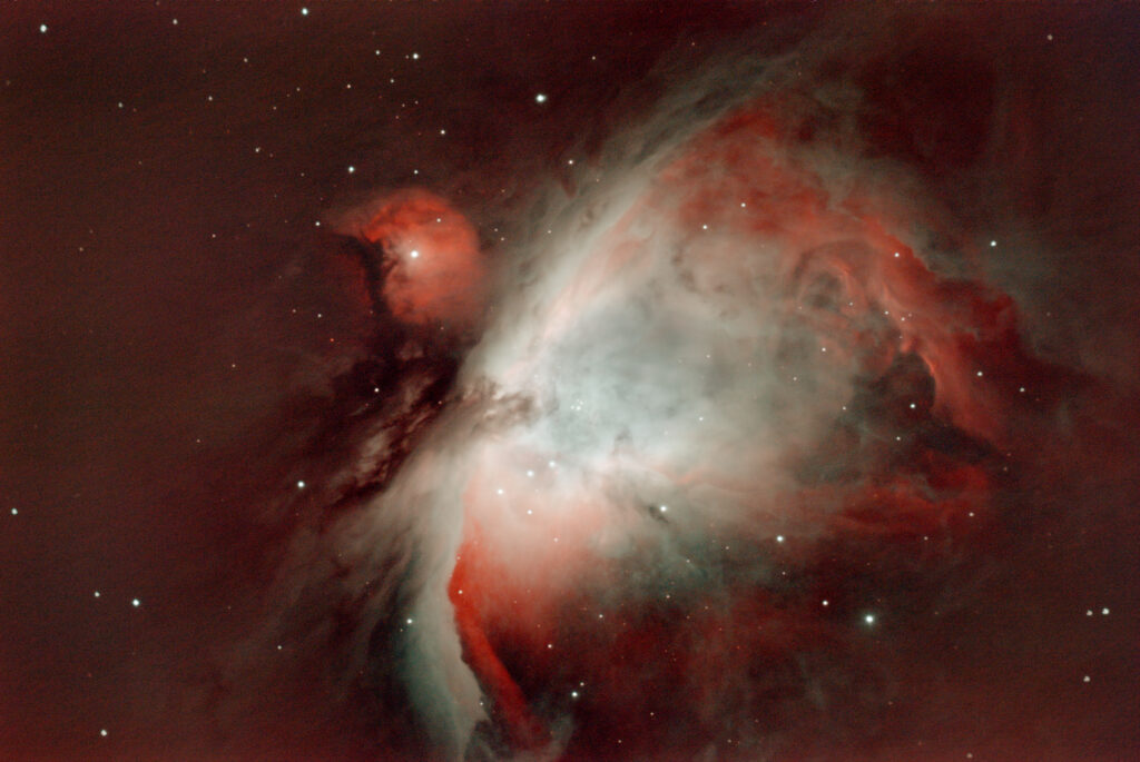 Astrophotography of M42, the Great Orion Nebula, showing dust clouds with red and white light