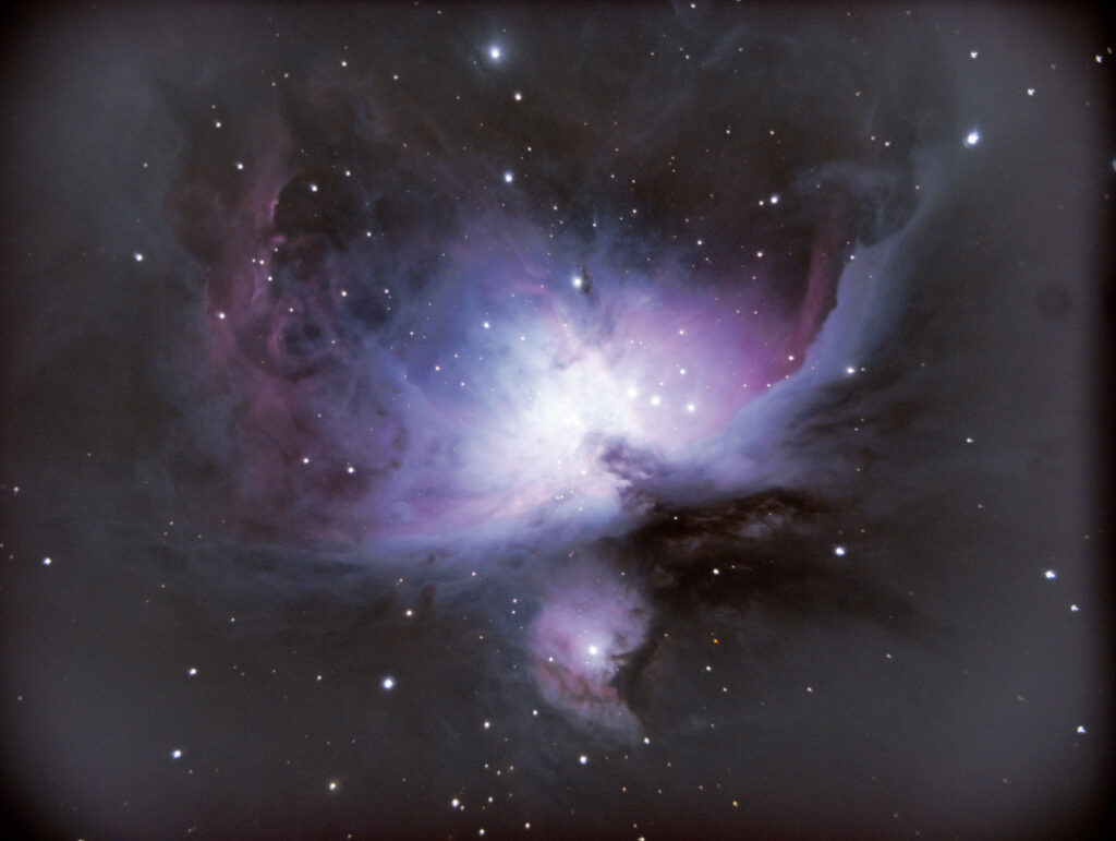 Astrophotography of M42 (Great Orion nebula) showing red and blue dust clouds in front of stars